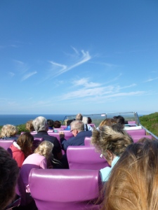 View of the sea from the top of an open-top bus with purple seats